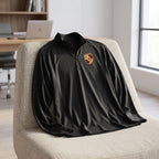 Casually draped black men's athletic shirt on lounge chair in bright home office setting.
