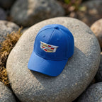 Cadillac Car Dad Baseball Cap Hat placed on a smooth outdoor rock, photographed from above to emphasize crown shape and embroidered design.