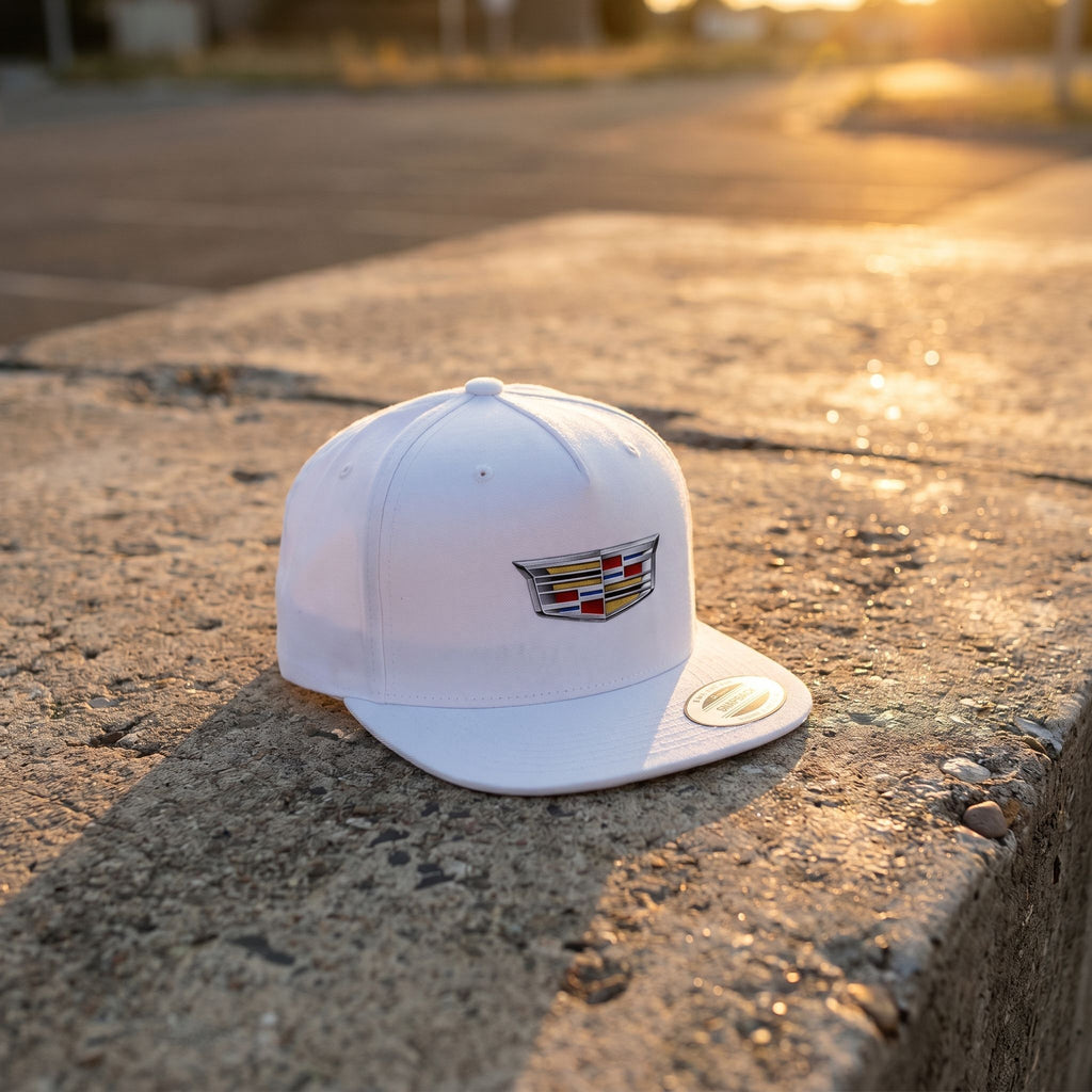 Small Cadillac Car Snapback Hat, lightweight cotton cap, tilted on a concrete surface during golden hour sunlight, emphasizing natural material details.