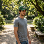 Full-body scene of male model wearing Cadillac Car Dad Baseball Cap in a park, natural sunlight, showing how the small cap fits on the head.