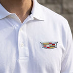 Close-up of Men’s Cadillac Car Dry Blend Polo showing textured cotton-polyester knit fabric, finished placket, dyed-to-match buttons, and structured collar.