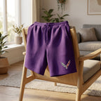 Indoor scene with men's Chevrolet Corvette fleece shorts draped over a minimalist chair, illuminated by natural light.
