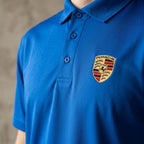 Close-up of chest fabric with reinforced stitching on men's Porsche polyester polo, emphasizing durability and smooth texture.