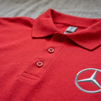 Close-up of finished placket with dyed-to-match buttons on men's Mercedes-Benz polo shirt.