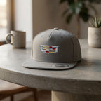 Full view of Cadillac Car Snapback Hat on concrete table highlighting its proportions and adjustable snapback.