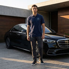 Full-body of man in black Mercedes-Benz polo next to luxury car, highlighting structured collar and confident posture.