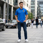 Male model wearing men's Porsche polyester polo in casual street setting, showcasing modern fit and breathable fabric.