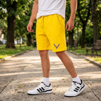Male model wearing Chevrolet Corvette fleece shorts in an urban park setting, highlighting comfort and stretch in natural sunlight.