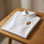 Flat lay of men's Porsche polyester polo on textured wooden surface, emphasizing slim fit and fabric quality.