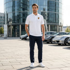 Full-body view of man wearing men's Porsche polyester polo in street environment, showcasing athletic fit and style.