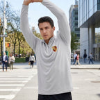 Male model in urban setting wearing Porsche athletic shirt, mid-motion, showcasing sporty cut, breathable fabric, and modern style.