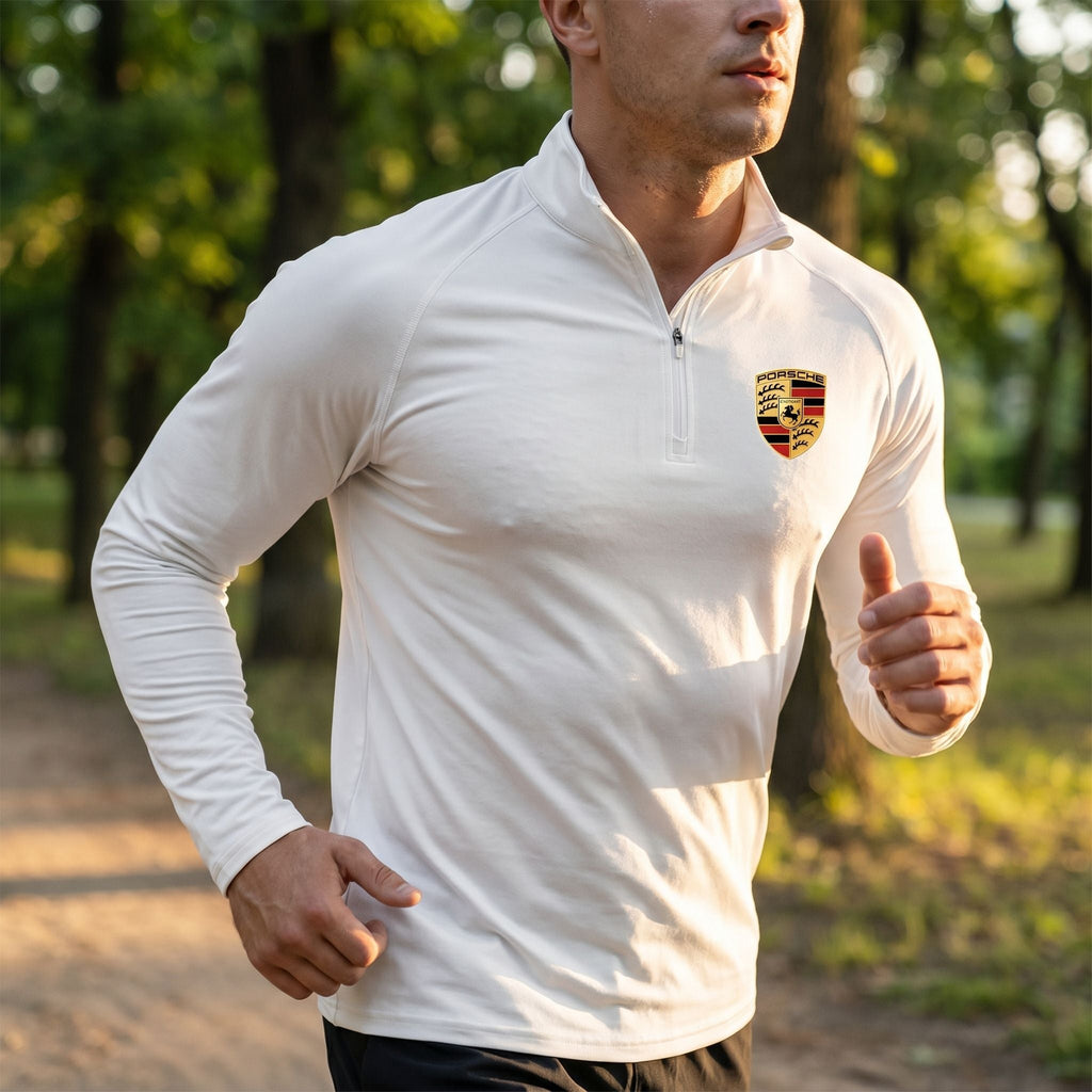 Male athlete wearing gray quarter-zip shirt running outdoors, illustrating breathable, moisture-wicking fabric.