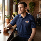 Lifestyle scene of the polo worn at a café table with coffee, focusing on relaxed fit and smooth placket, captured from above in natural sunlight.