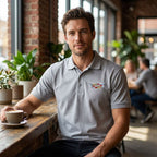 Lifestyle shot of male at café wearing Cadillac Polo, focus on collar and casual style.