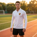 Male model wearing men's athletic quarter-zip shirt outdoors on a track during golden hour emphasizing fabric's quick-dry and breathable features.