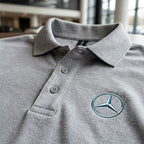 Macro shot of the fabric detail of men's Mercedes-Benz dry blend polo, highlighting weave, moisture-wicking texture, and collar finish.