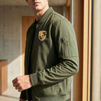 Close-up of men's Porsche lightweight bomber jacket highlighting softshell fabric and sleek design.