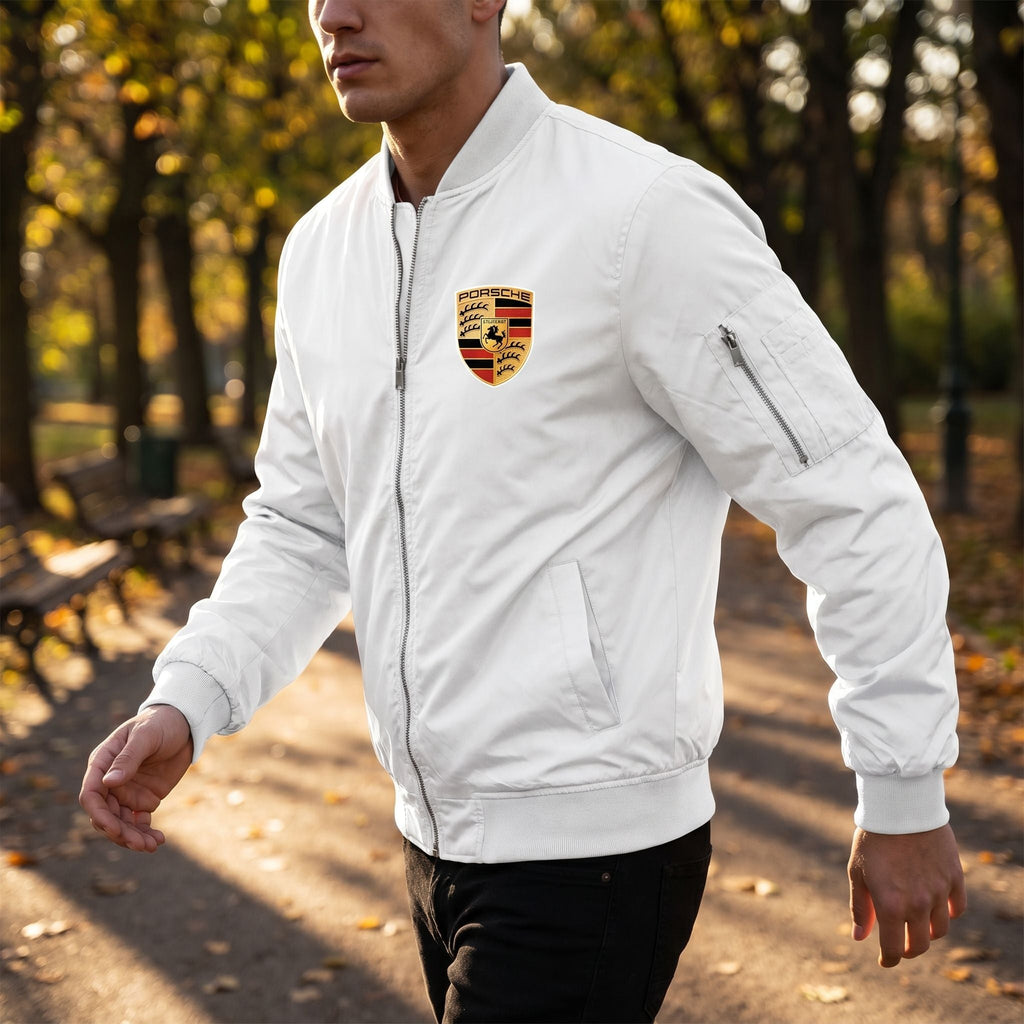 Male model walking in park wearing Porsche softshell bomber jacket, capturing movement and fabric details.