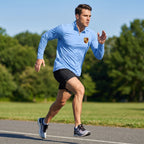Male athlete wearing Porsche-inspired quarter-zip shirt running outdoors, highlighting athletic fit and stretch fabric.