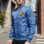 Men's Porsche lightweight bomber jacket displayed on a model in an urban street scene highlighting its softshell fabric, structured details, and modern style.