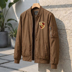 Angled view of Porsche windbreaker jacket on hanger in outdoor patio, emphasizing lightweight fabric and clean design.